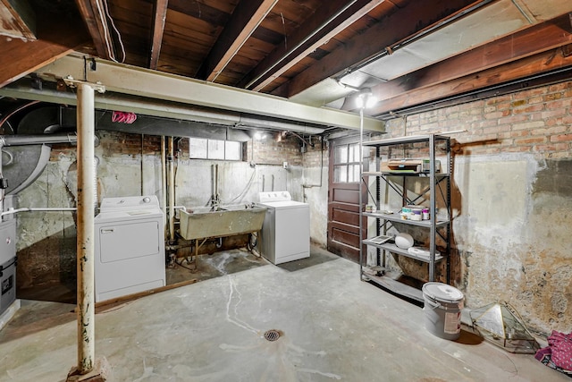 basement featuring separate washer and dryer and sink