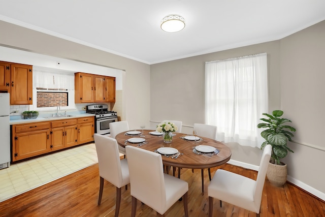 dining area featuring a healthy amount of sunlight, light wood-type flooring, and sink