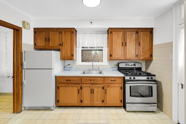 kitchen featuring sink, white fridge, and stainless steel gas range