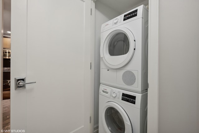 washroom with stacked washer / dryer and hardwood / wood-style floors