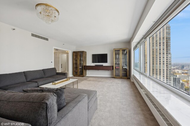 carpeted living room with a notable chandelier