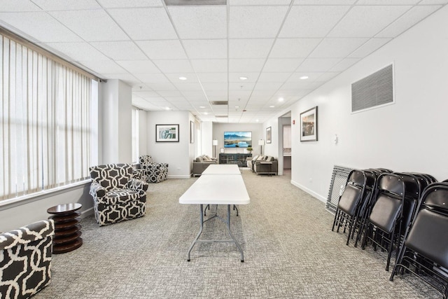 living room featuring carpet flooring and a drop ceiling