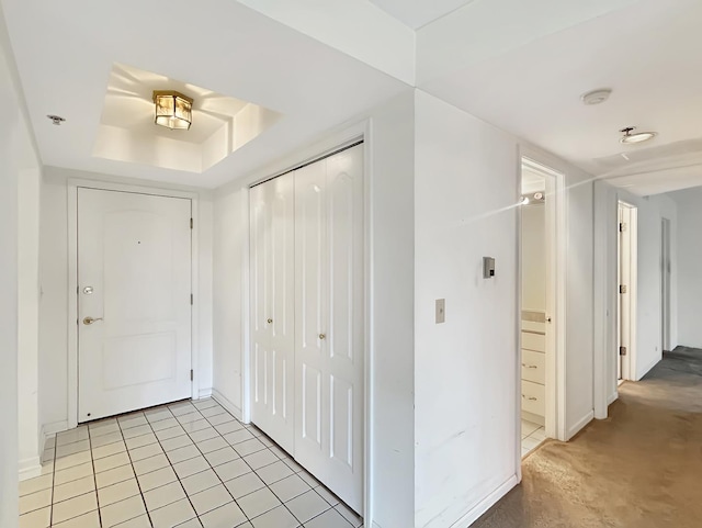 tiled entryway with a tray ceiling