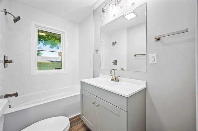 full bathroom with wood-type flooring, vanity, toilet, and tiled shower / bath combo