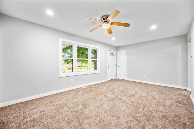 empty room featuring ceiling fan and carpet