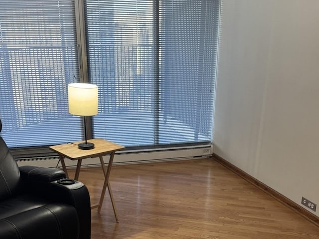 living area with baseboard heating and hardwood / wood-style floors