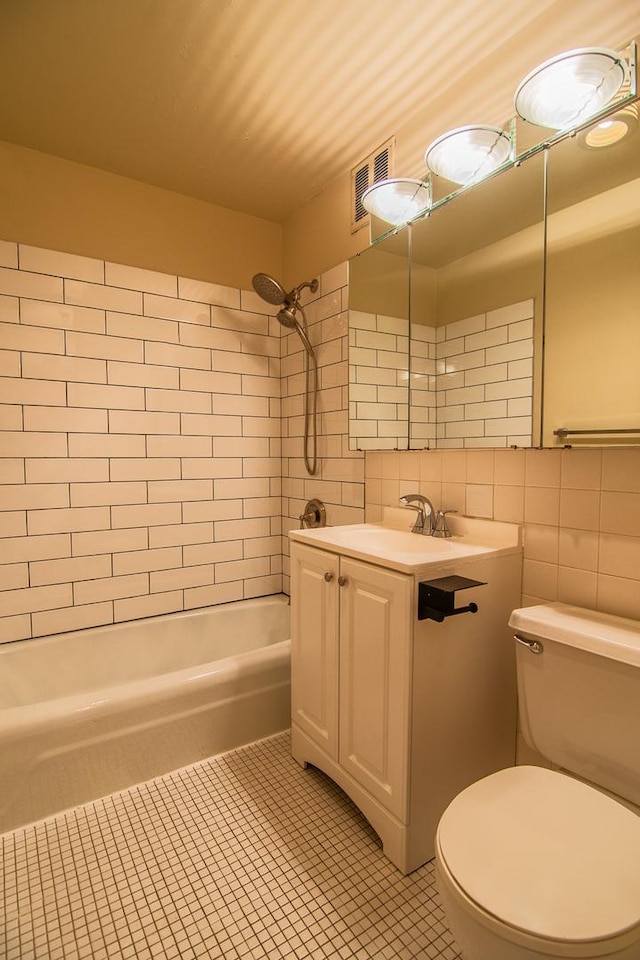 full bathroom featuring vanity, backsplash, tile patterned flooring, toilet, and tile walls