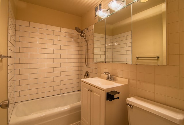 full bathroom featuring tiled shower / bath combo, tasteful backsplash, toilet, vanity, and tile walls