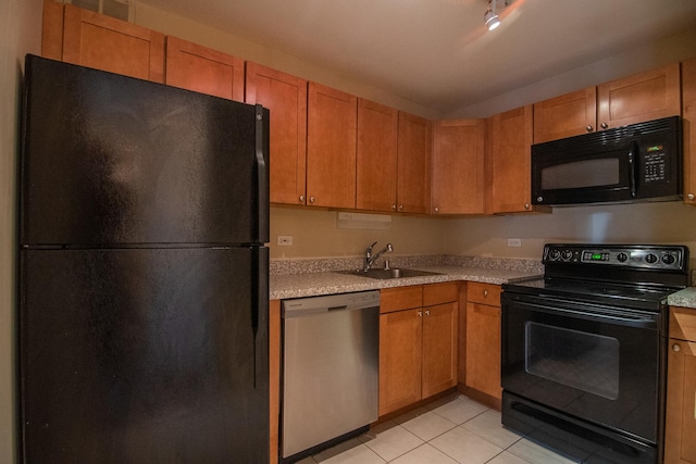 kitchen with black appliances, light tile patterned flooring, and sink