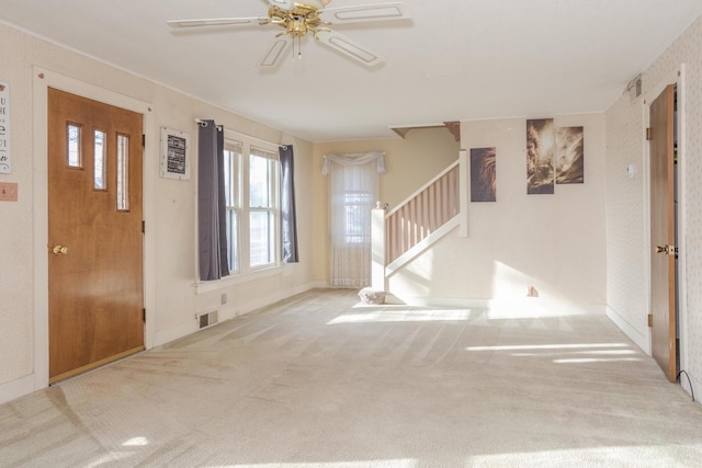 carpeted entrance foyer featuring ceiling fan