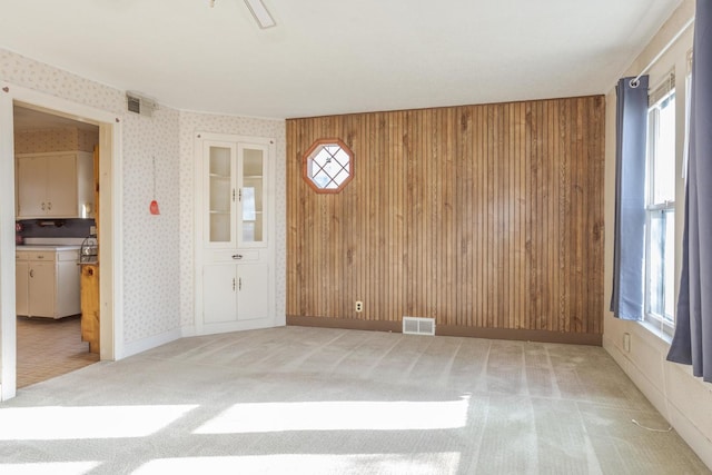 entryway with wooden walls and light colored carpet