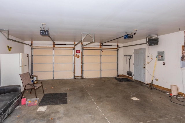 garage featuring electric panel, white fridge, and a garage door opener