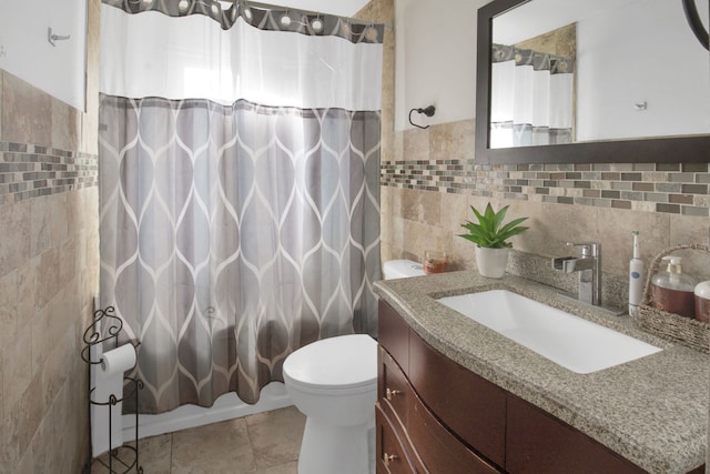 bathroom with tile patterned flooring, vanity, tile walls, and toilet