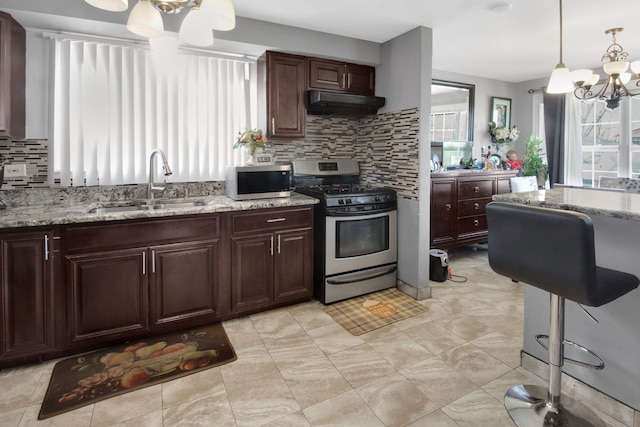 kitchen featuring sink, hanging light fixtures, stainless steel appliances, a chandelier, and decorative backsplash