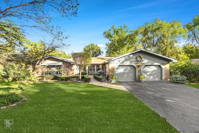 single story home featuring a garage and a front lawn