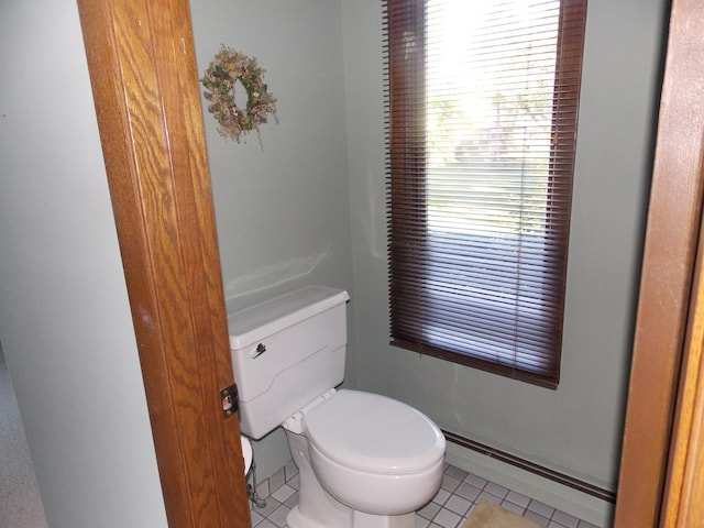 bathroom with tile patterned flooring, a baseboard radiator, and toilet