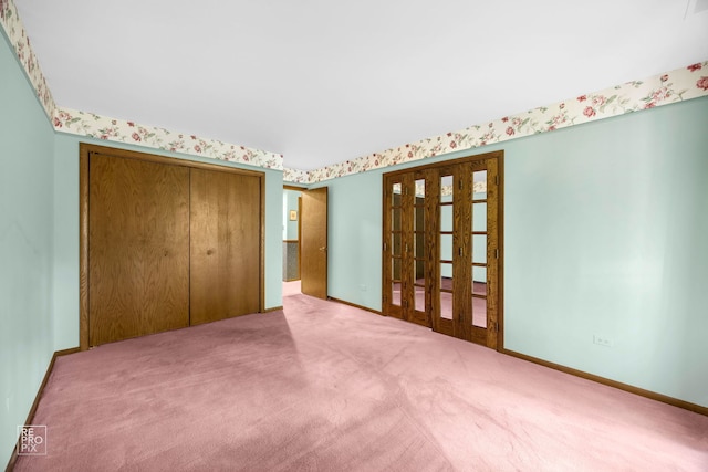 unfurnished bedroom featuring a closet, carpet floors, and french doors