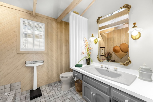 bathroom with wooden walls, sink, tile patterned flooring, and toilet