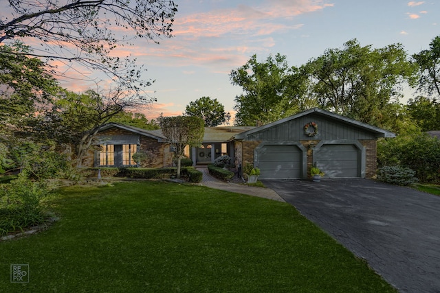 single story home featuring a garage and a yard