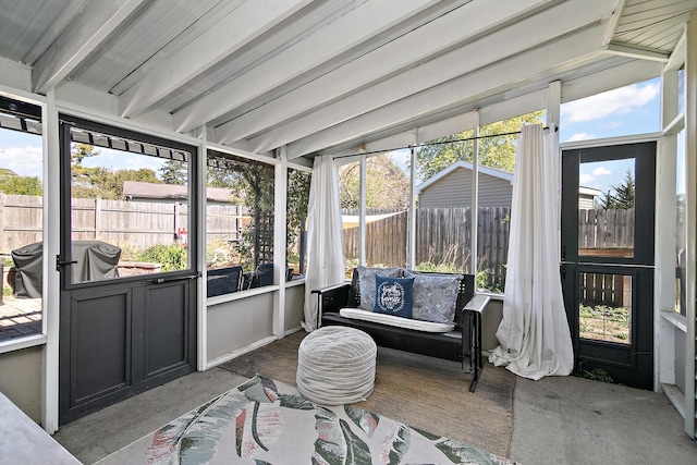 sunroom / solarium featuring beamed ceiling