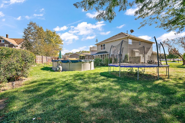 view of yard with a covered pool and a trampoline