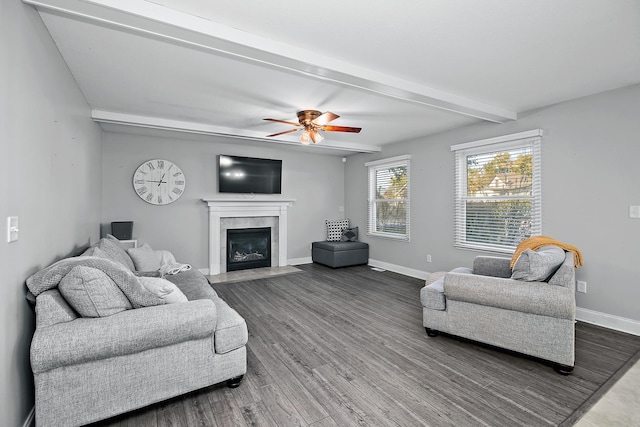 living room with beamed ceiling, ceiling fan, wood-type flooring, and a fireplace