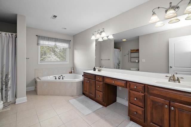 bathroom with tile patterned flooring, vanity, tiled bath, and toilet