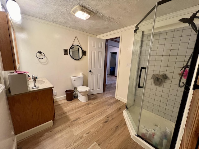 bathroom featuring vanity, hardwood / wood-style flooring, walk in shower, and crown molding