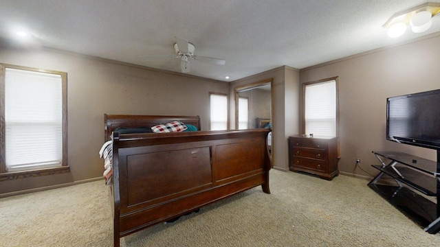 carpeted bedroom with ceiling fan, a textured ceiling, and ornamental molding