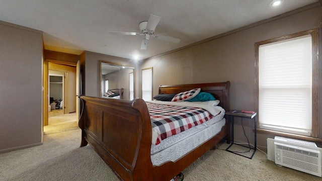 carpeted bedroom with ceiling fan, a wall mounted air conditioner, and ornamental molding