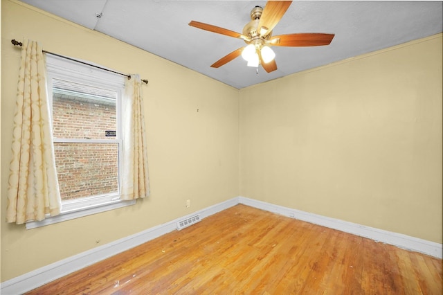 empty room with ceiling fan, a healthy amount of sunlight, and wood-type flooring