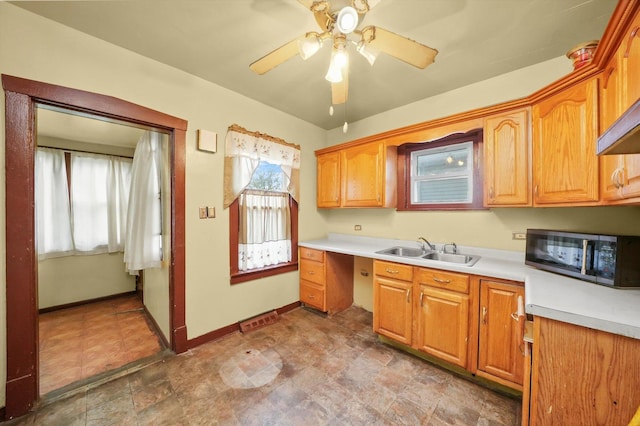 kitchen featuring ceiling fan and sink