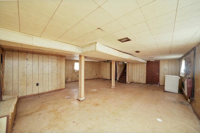 basement with light colored carpet and wooden walls