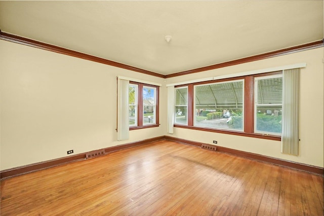 unfurnished room featuring crown molding and wood-type flooring