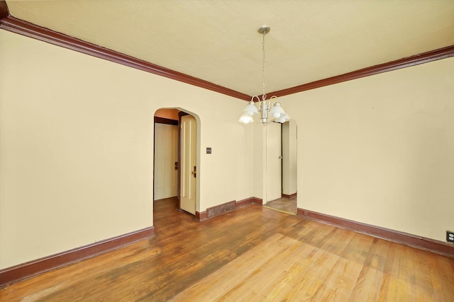 unfurnished dining area with a chandelier, wood-type flooring, and ornamental molding