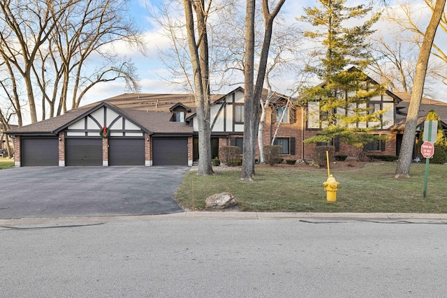 tudor home featuring a front yard and a garage