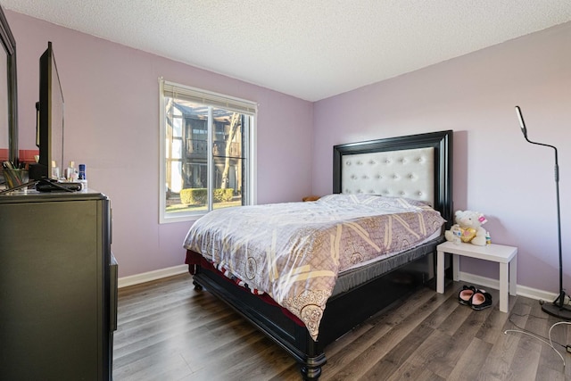 bedroom featuring a textured ceiling and dark hardwood / wood-style floors