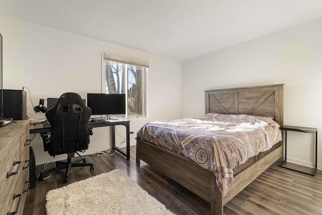 bedroom featuring dark hardwood / wood-style flooring and a textured ceiling