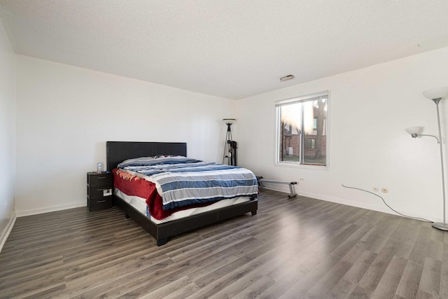 bedroom featuring a textured ceiling and dark wood-type flooring