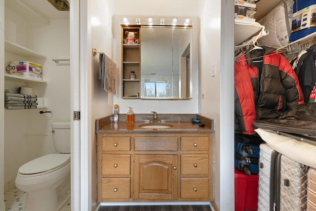 bathroom with hardwood / wood-style floors, vanity, and toilet