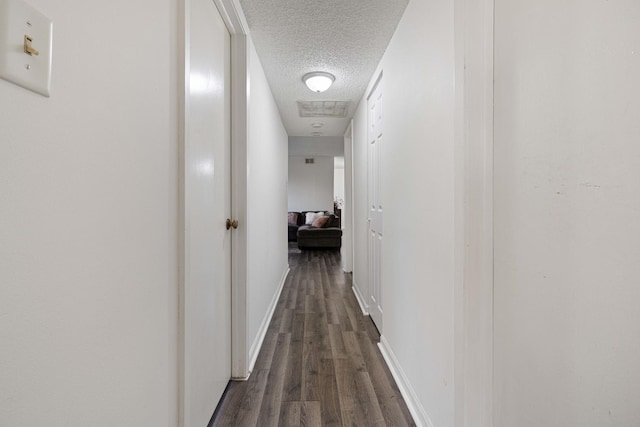 hallway featuring dark hardwood / wood-style floors and a textured ceiling