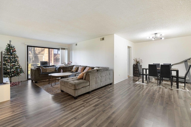 living room featuring dark hardwood / wood-style flooring, a chandelier, and a textured ceiling