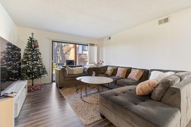 living room featuring dark hardwood / wood-style floors and a textured ceiling