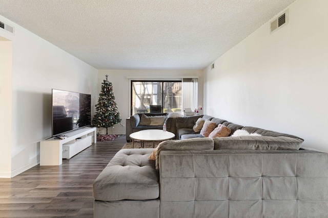 living room featuring a textured ceiling and dark hardwood / wood-style floors