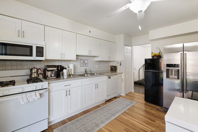 kitchen with light hardwood / wood-style floors, white cabinetry, white appliances, and sink