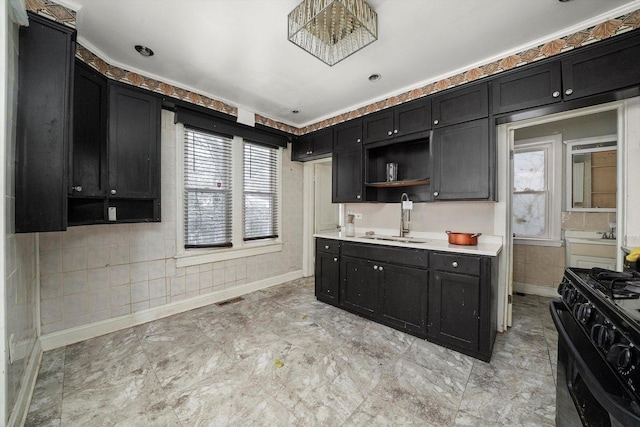 kitchen featuring black range, a healthy amount of sunlight, and sink