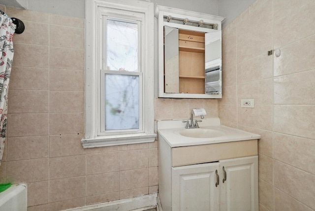 bathroom featuring vanity and tile walls