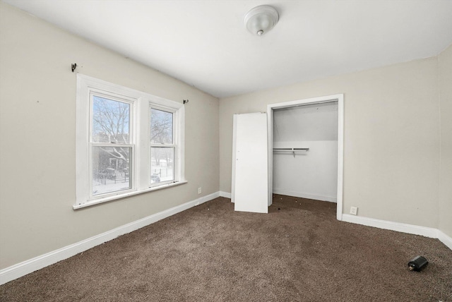 unfurnished bedroom with a closet and dark colored carpet