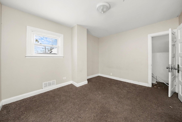 unfurnished bedroom with dark carpet