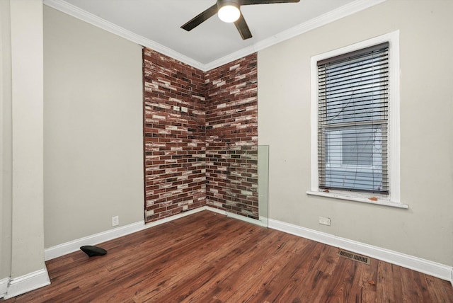 unfurnished room featuring crown molding, hardwood / wood-style floors, and brick wall